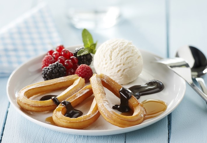Churros med glass, bär och mörk chokladsås